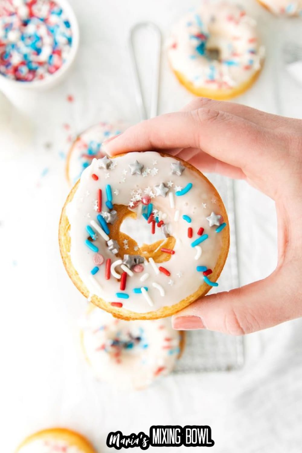 red white and blue donut held in a woman's hand