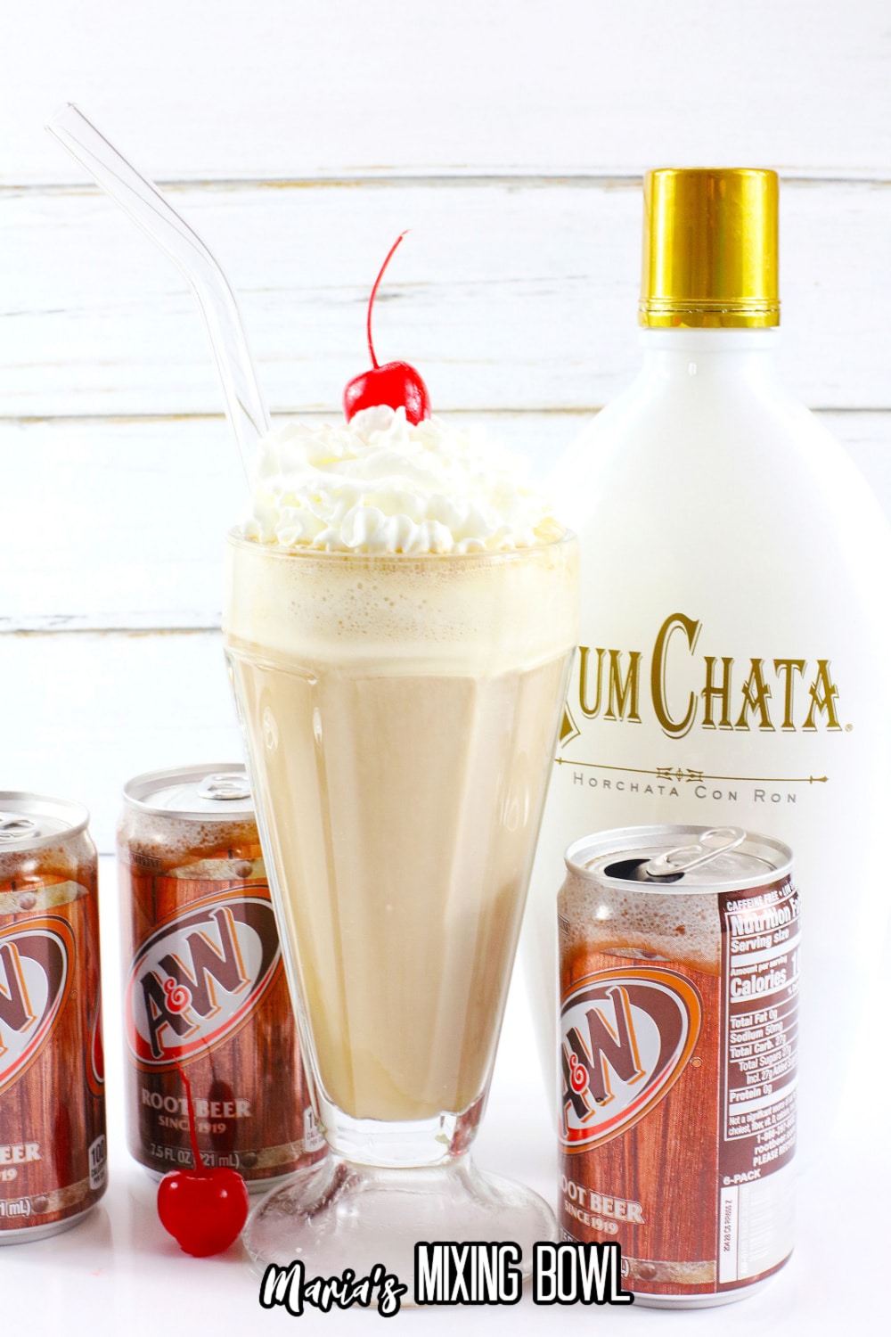 milkshake glass filled with a root beer float topped with whipped cream and a cherry