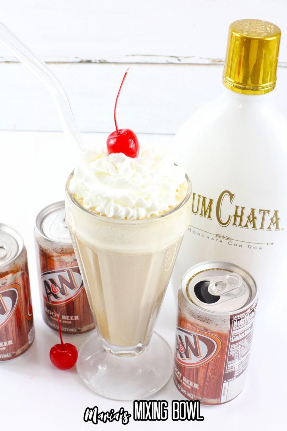 milkshake glass filled with a root beer float topped with whipped cream and a cherry