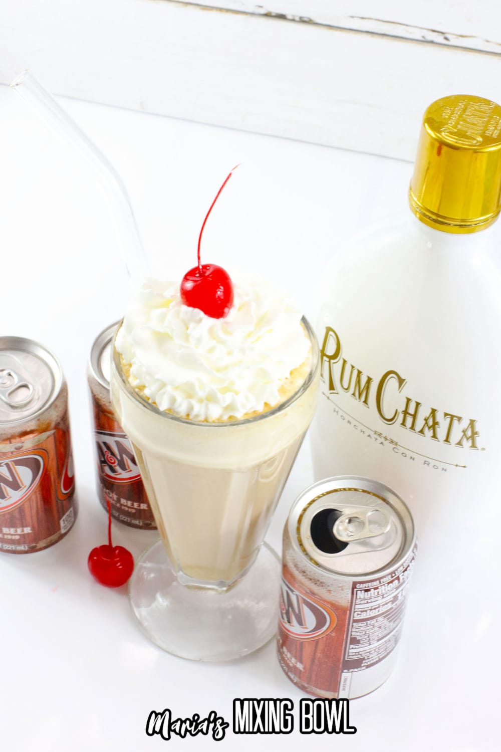 milkshake glass filled with a root beer float topped with whipped cream and a cherry
