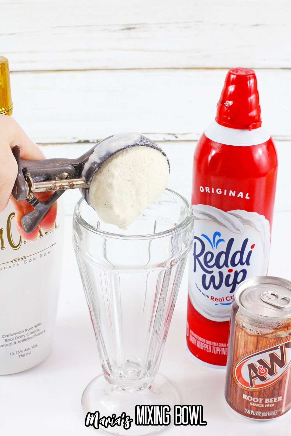 ice cream scoop being dropped into a milkshake glass