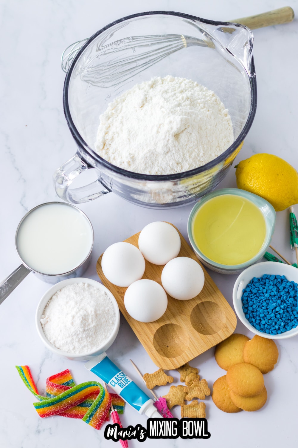 ckae mix, eggs, condensed milk, sprinkles, nilla wafers, teddy grahams, milk, and pudding mix on a white background