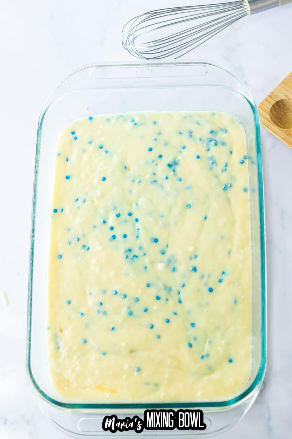 cake mix with blue sprinkles in a glass baking dish