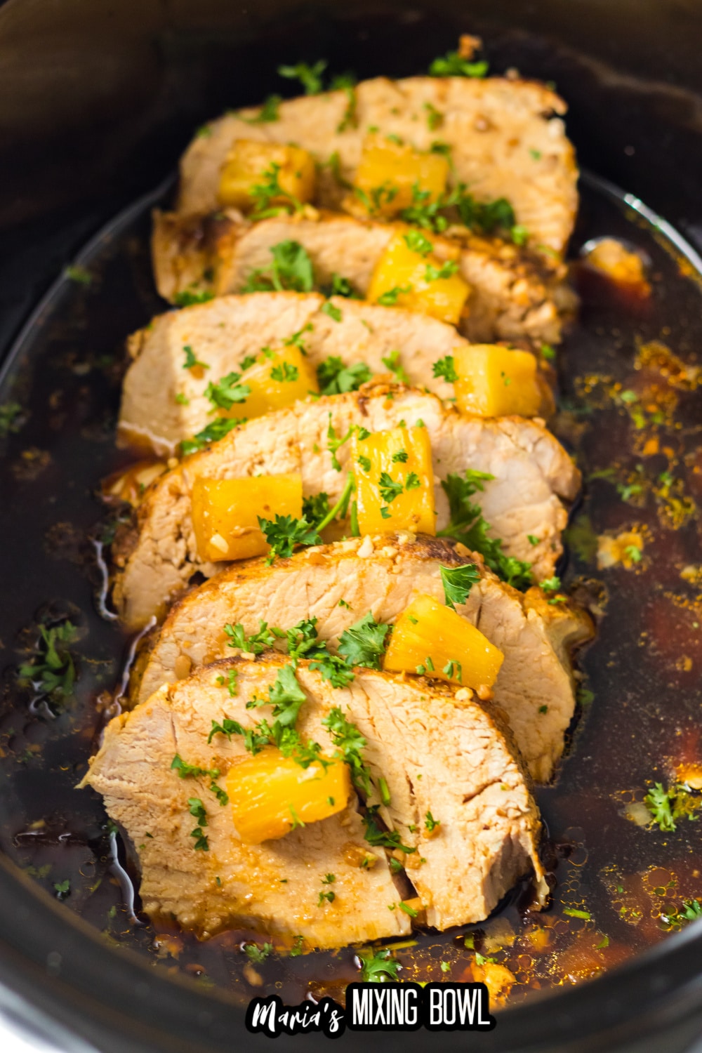 sliced tenderloin topped with parsley in a slow cooker