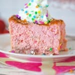 slice of strawberry confetti cheesecake on a white plate