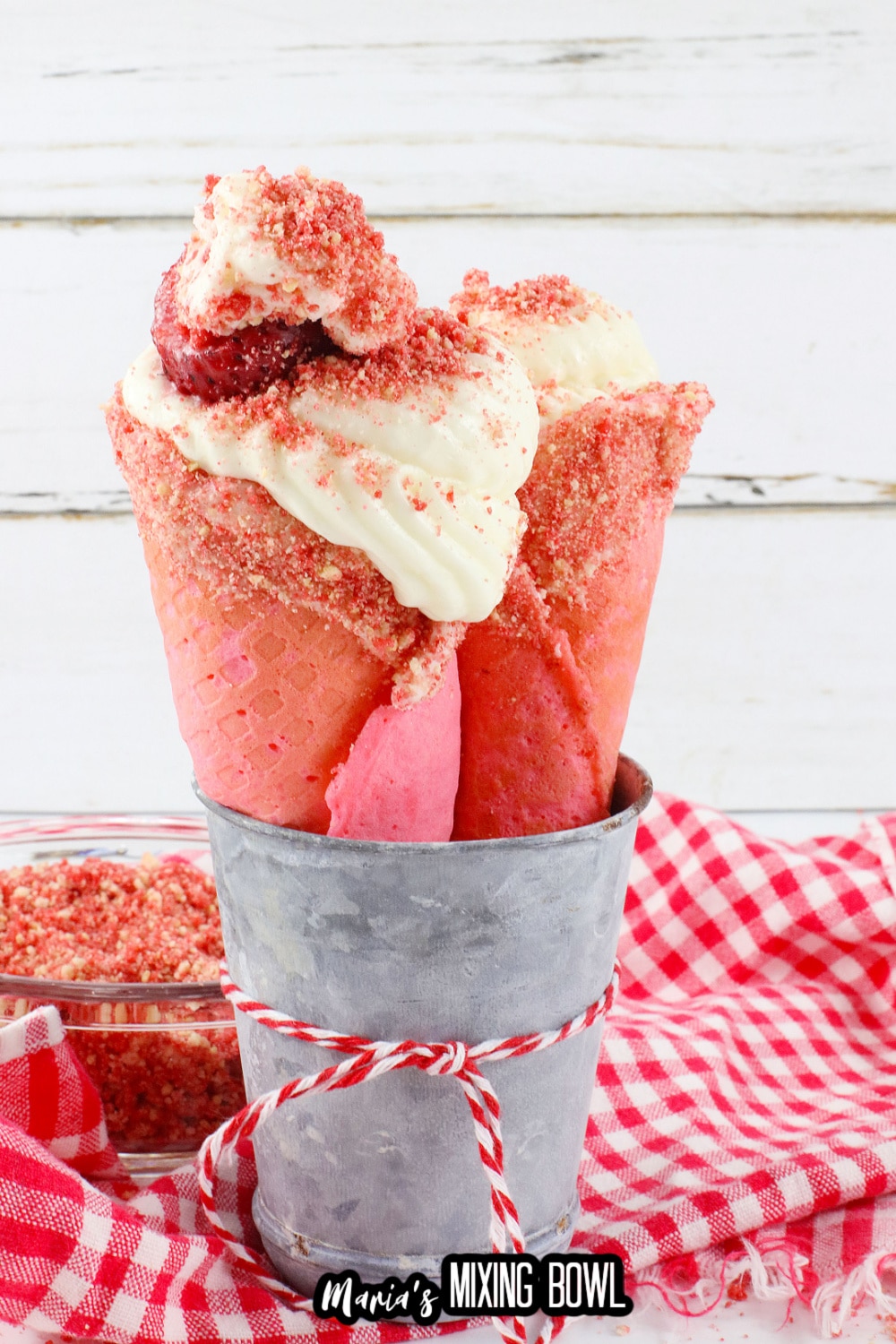 two strawberry cheesecake cones in a metal bowl
