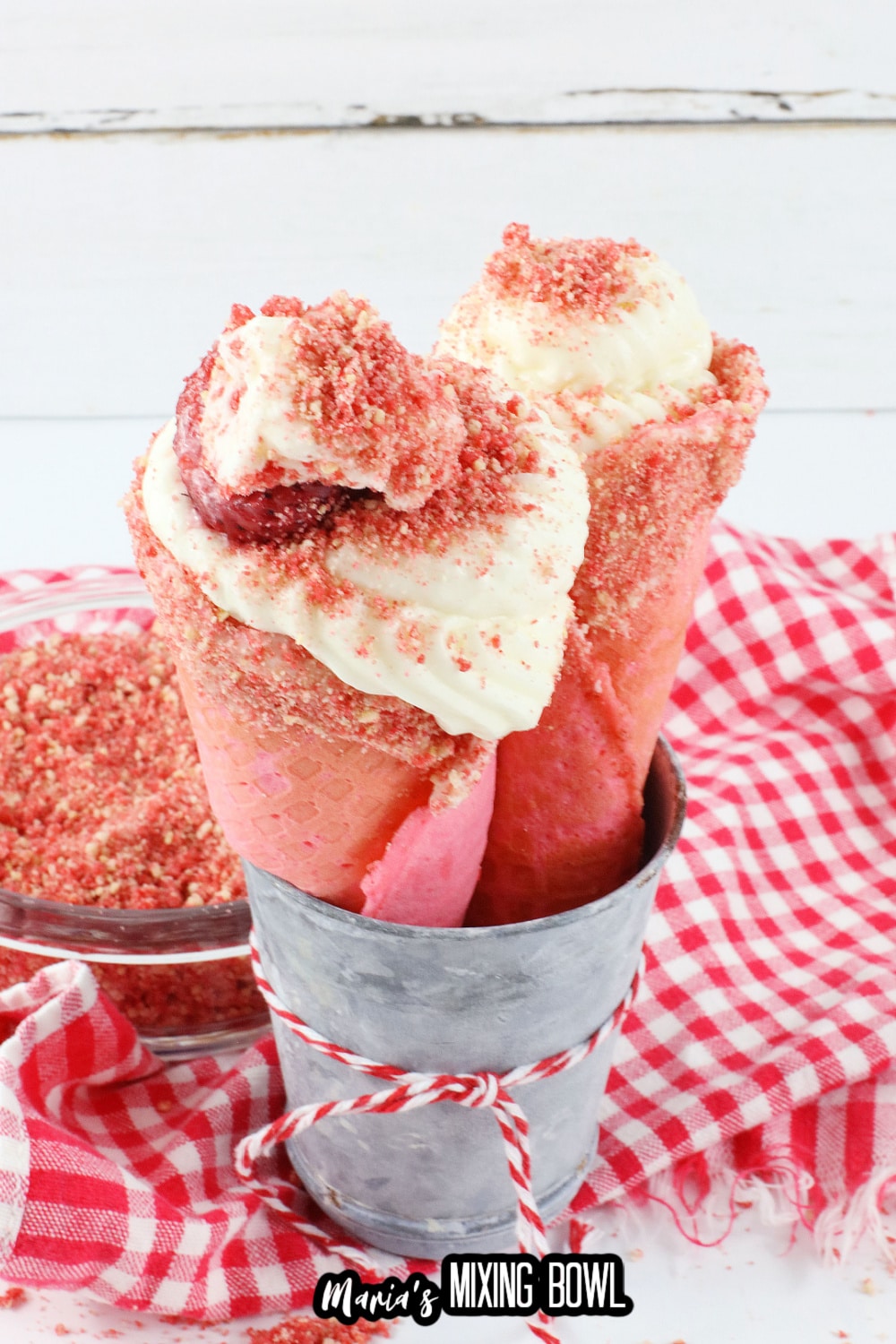two strawberry cheesecake cones in a metal bowl