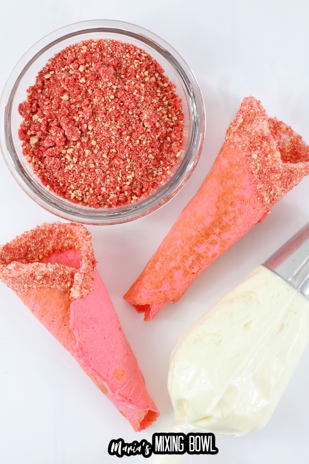 strawberry crunch being added to dipped waffle cones