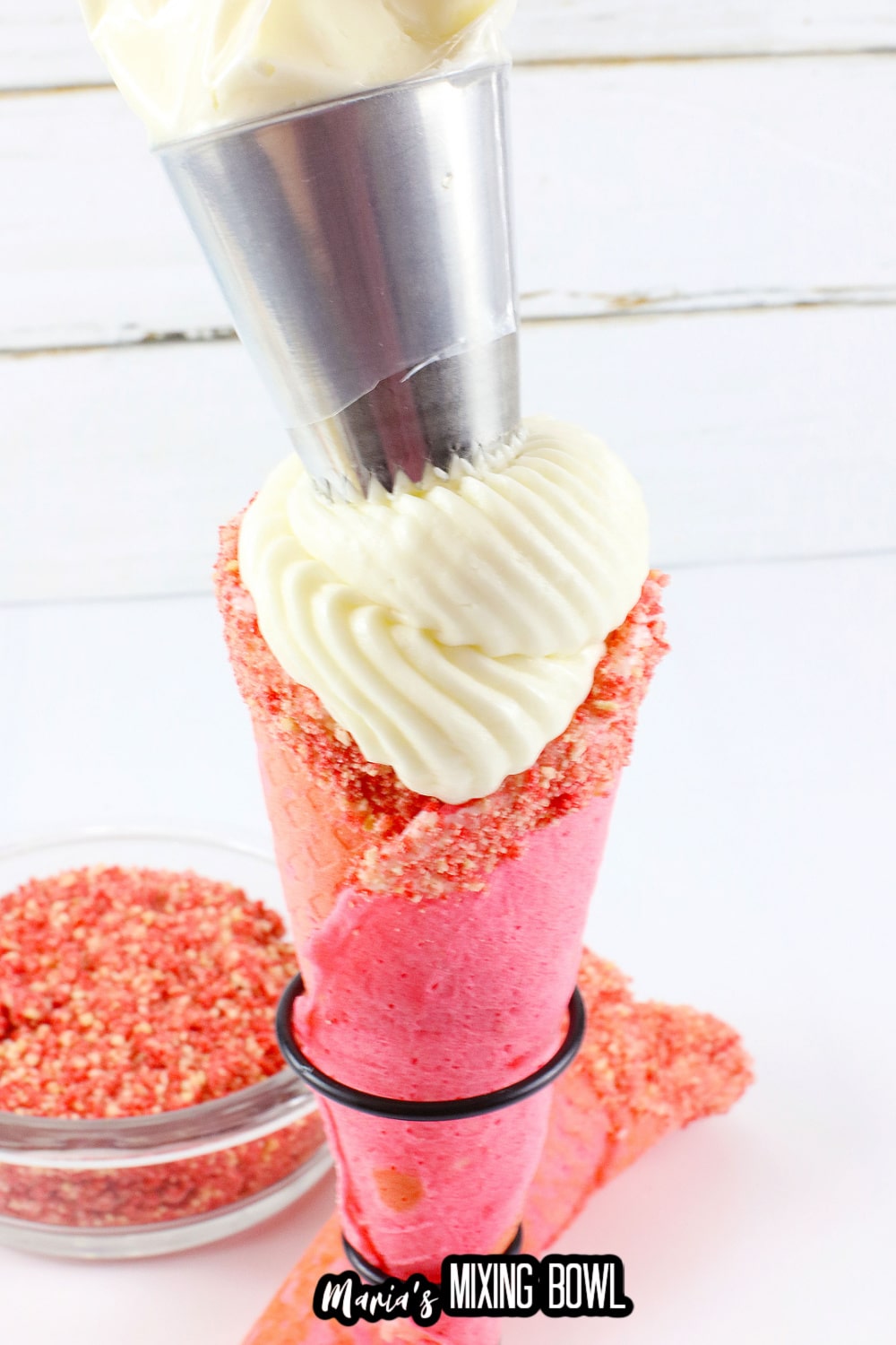 cheesecake filling being piped into a waffle cone