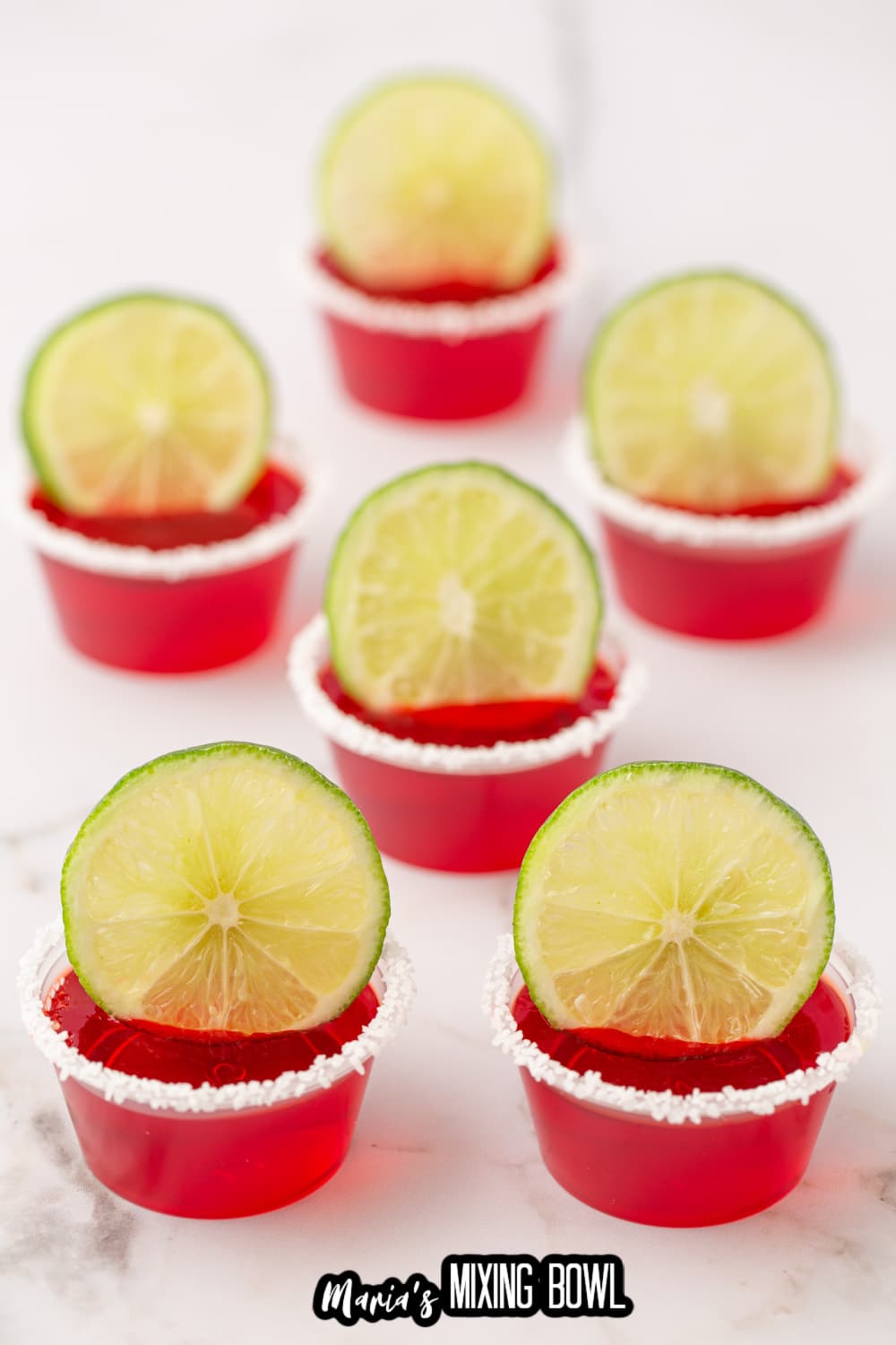 margarita shots rimmed with salt and a lime wedge
