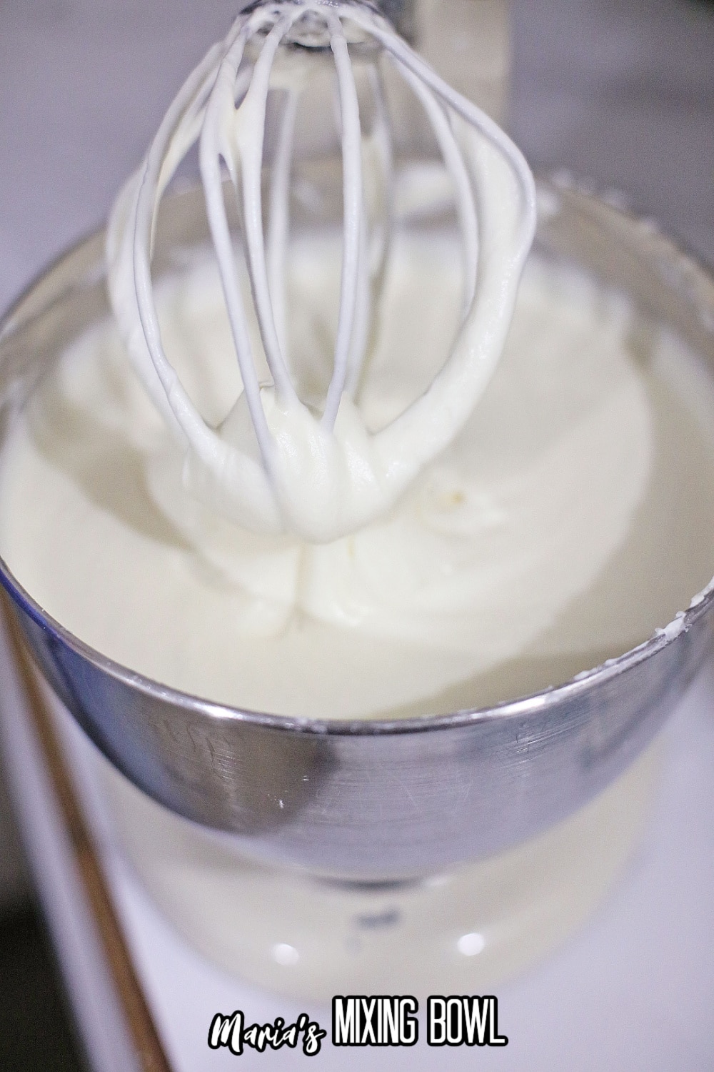 cream cheese and sugar mixed in a stainless steel mixing bowl to a stand mixer