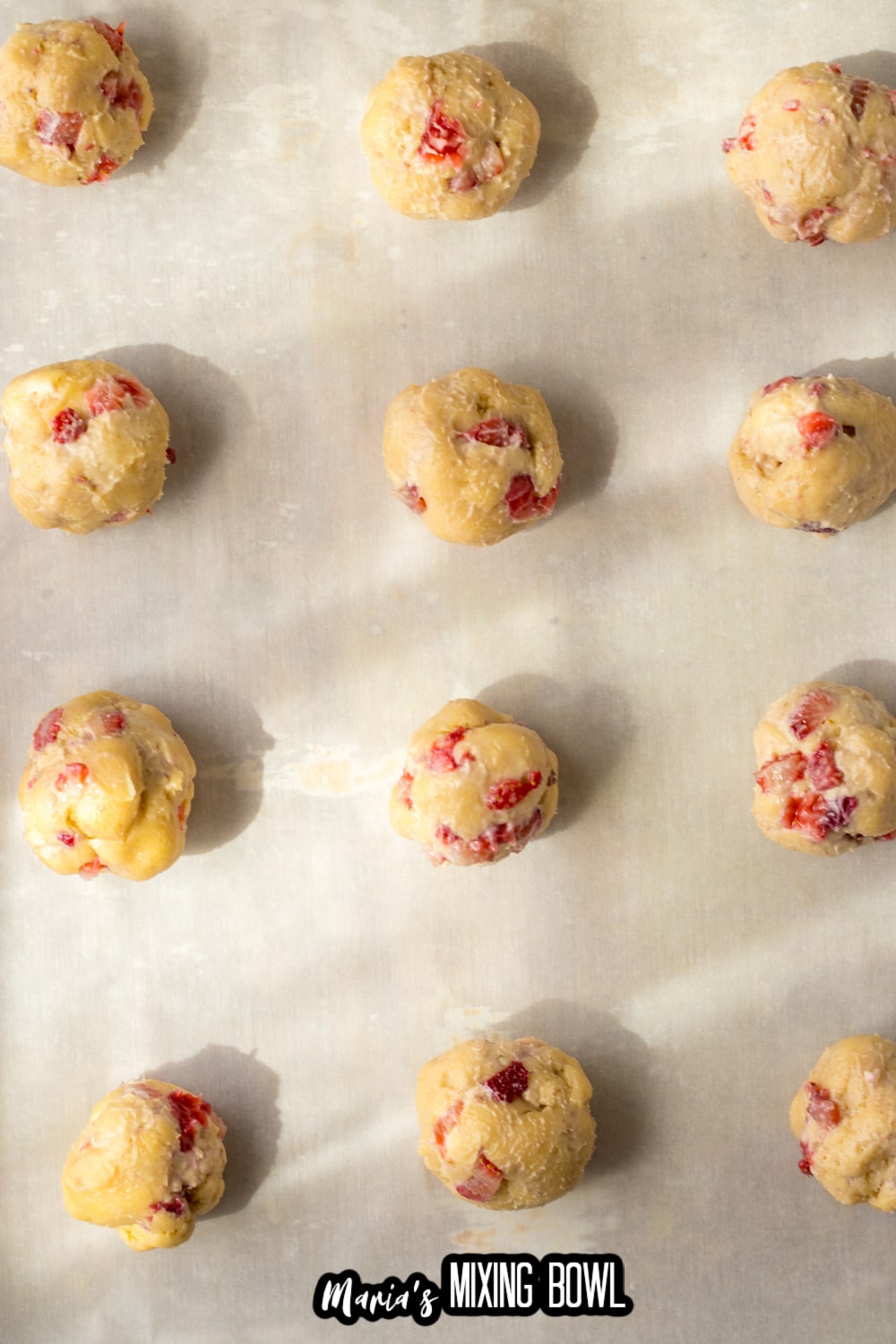 cookie dough balls on a parchment lined baking sheet