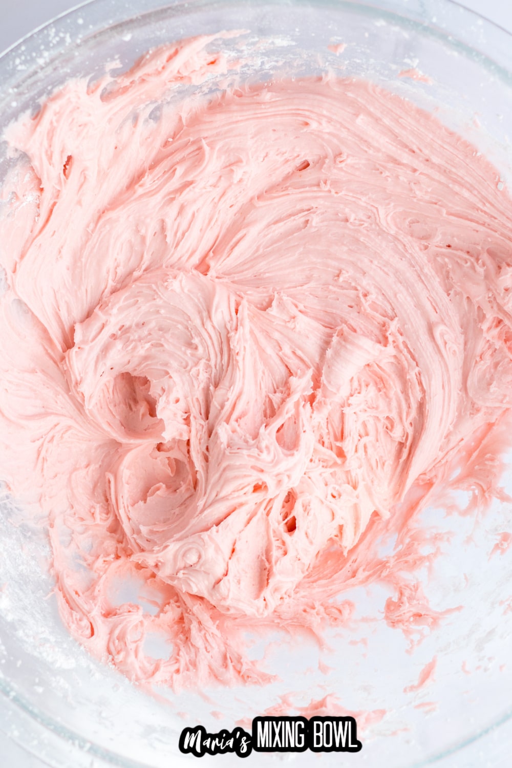 strawberry frosting in a glass mixing bowl