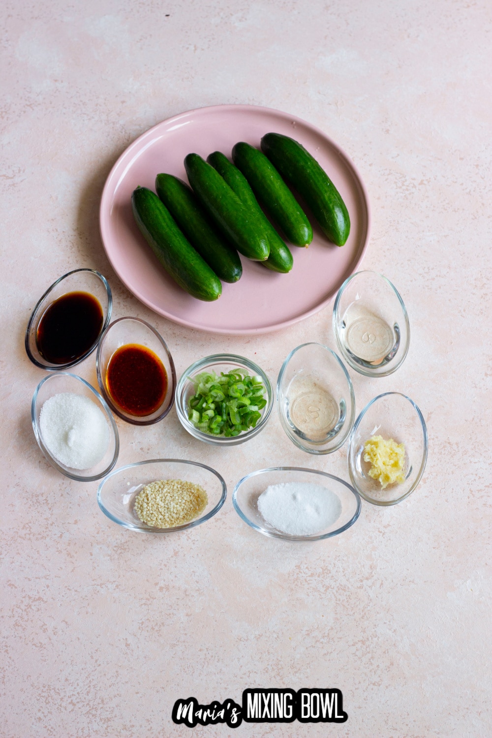whole cucumbers, green onions, salt, soy sauce, rice vinegar, and garlic in a bowls