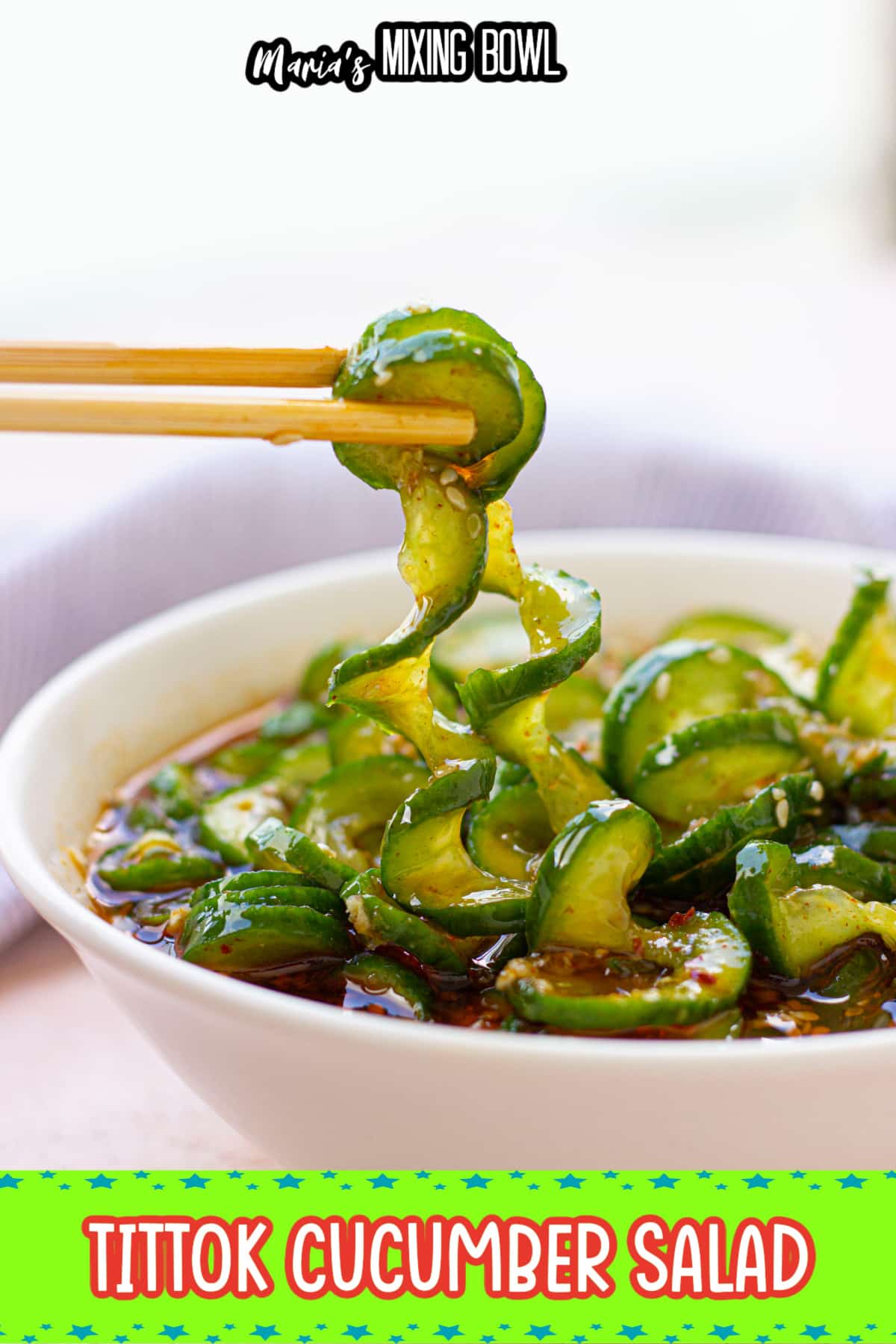 cucumber salad in a white bowl with a stack of cucumbers behind it