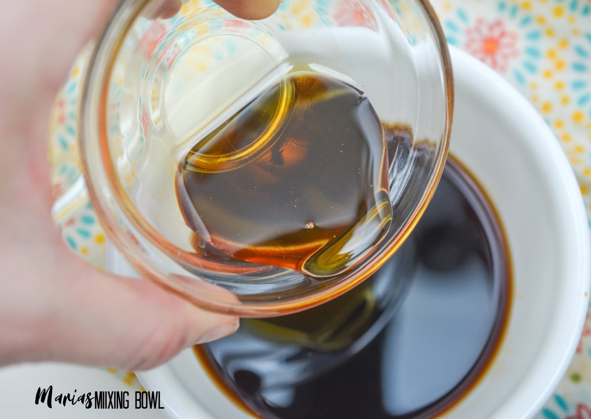 pouring Sesame oil into a small mixing bowl to make the sauce