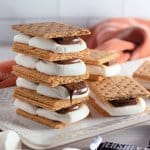 four baked smores stack on top of each other on a white plate