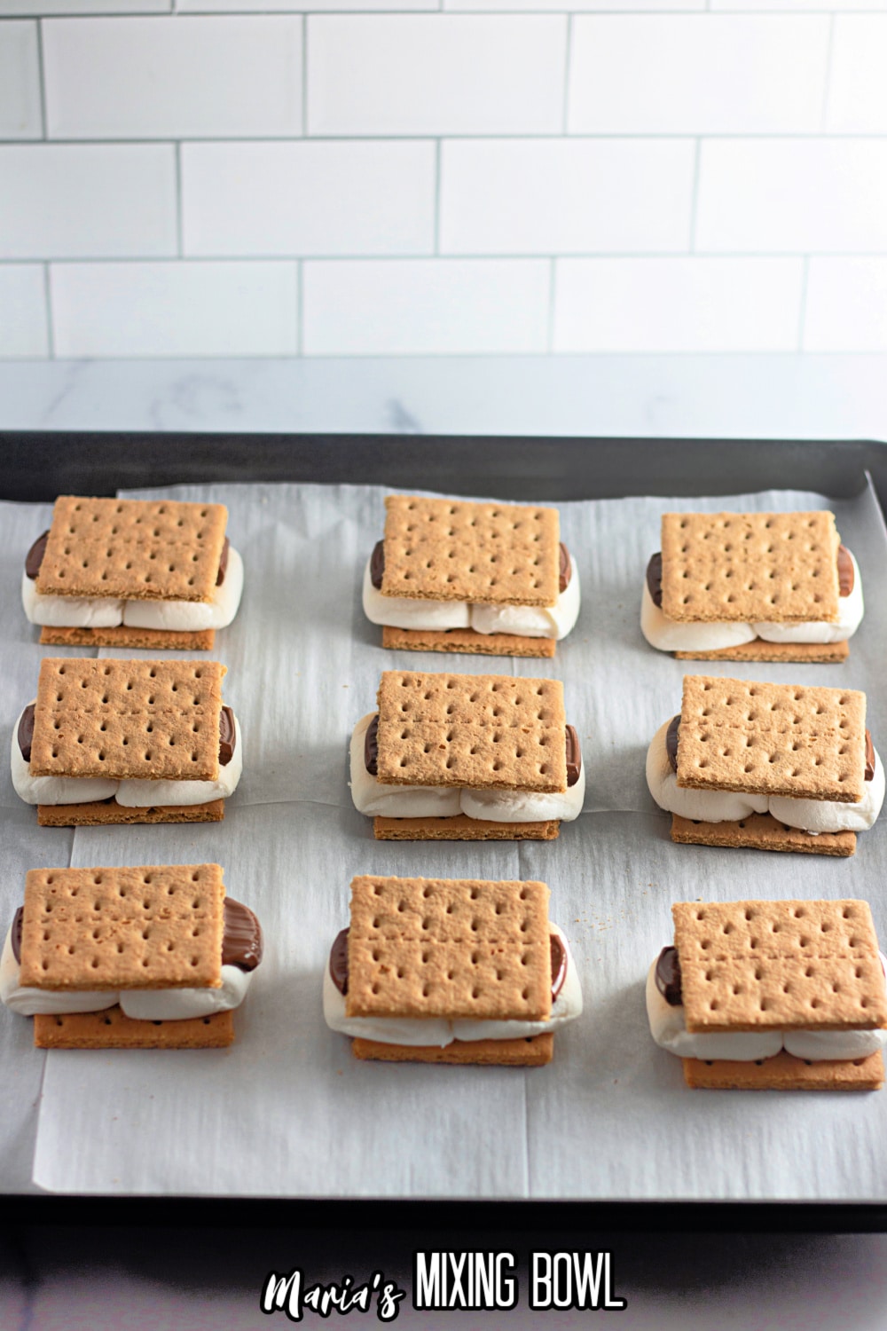 finished smores on a parchment lined baking sheet