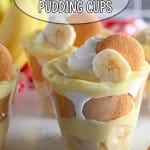 banana pudding in a clear plastic cup with a bunch of bananas in the background