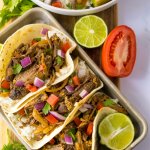 copycat chipotle barbacoa tacos on a metal baking tray with a lime half