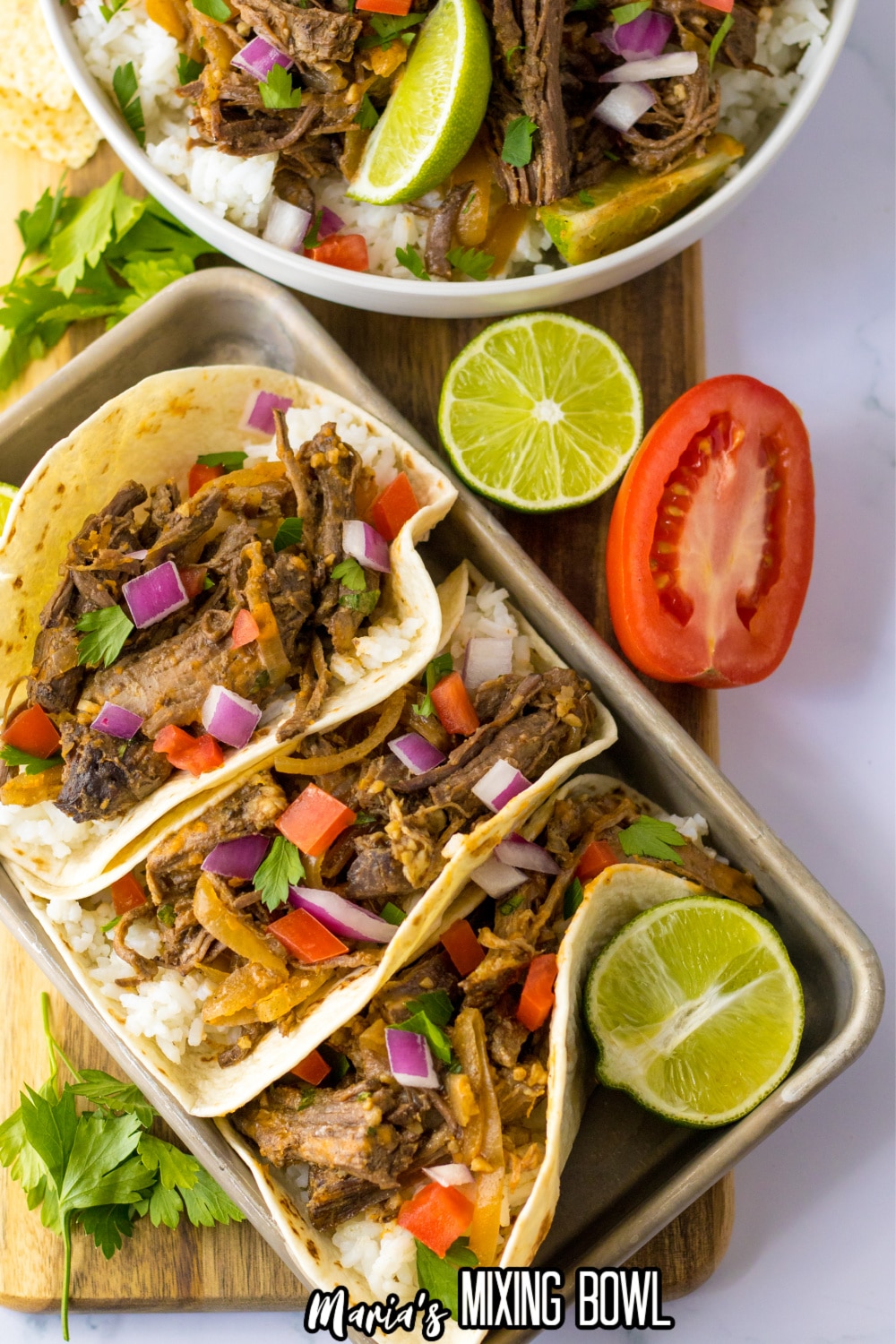 copycat chipotle barbacoa tacos on a metal baking tray with a lime half