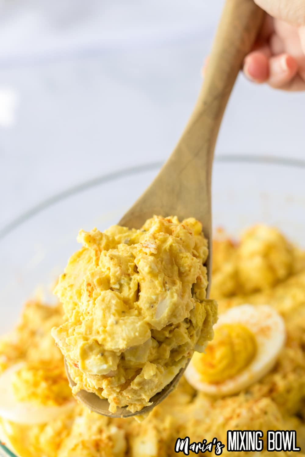 wooden spoon full of deviled egg potato salad