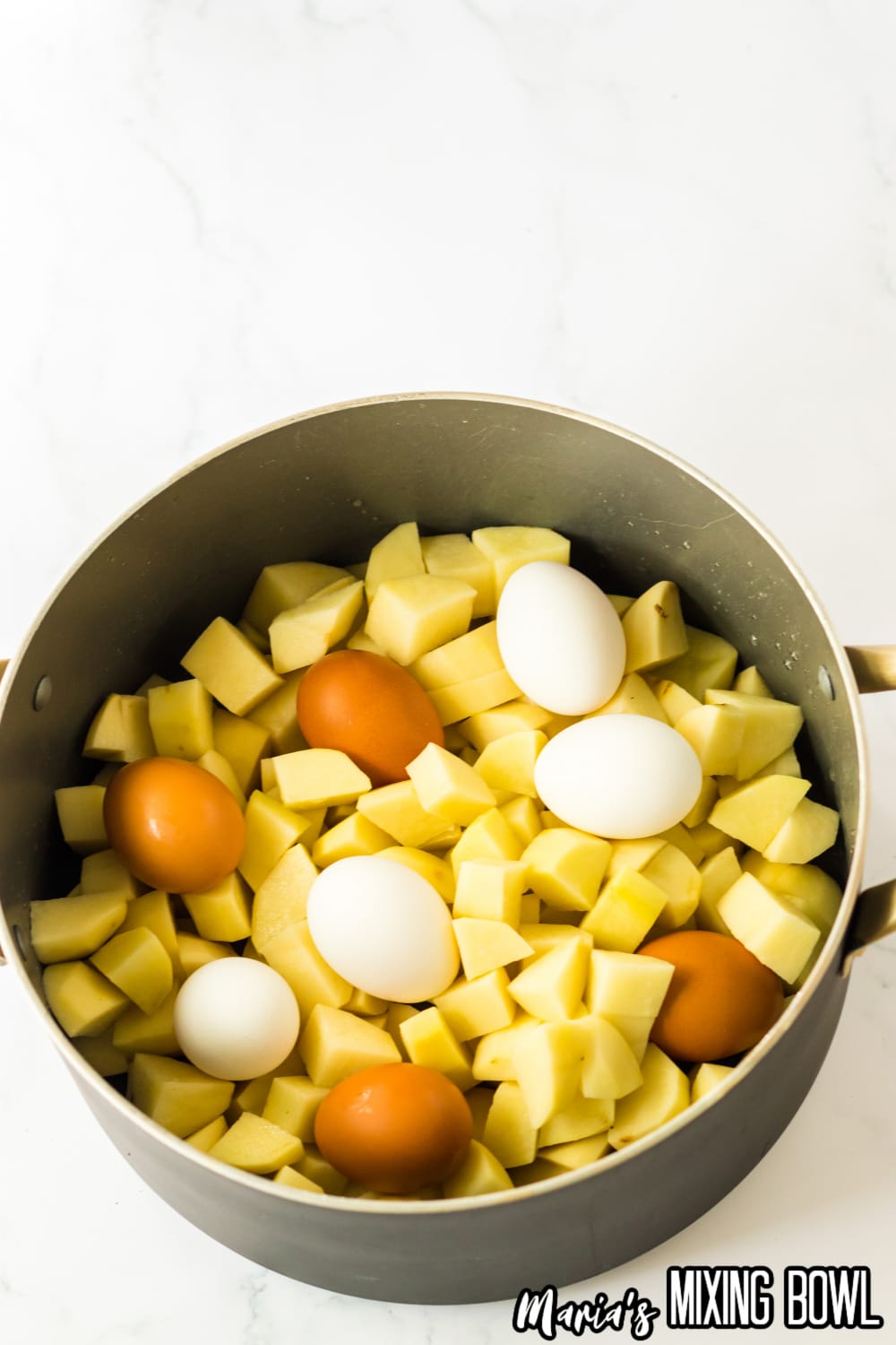 diced potatoes and raw eggs in the shell in a large pot