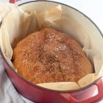 baked dutch oven bread in a parchment lined dutch oven