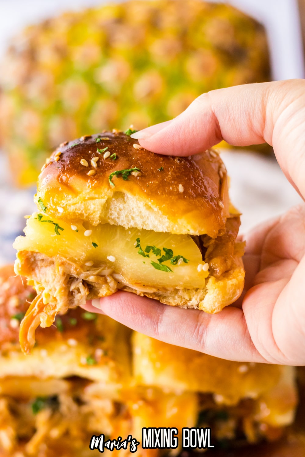 hawaiian chicken slider held in a woman's hand