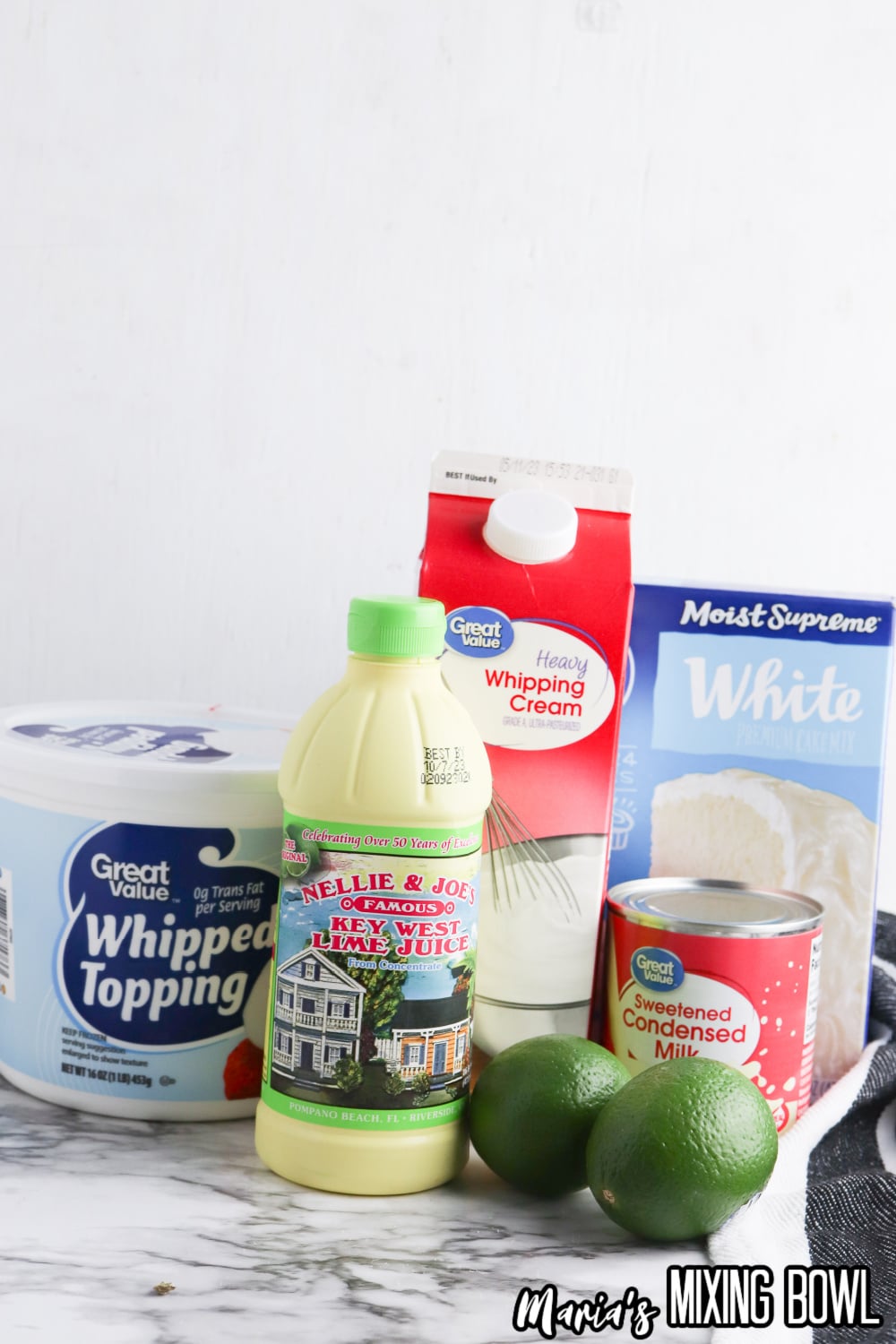whipped topping, key lime juice, whipping cream, limes, sweetened condensed milk and white cake mix on a marble counter