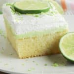 finished key lime poke cake in a glass baking dish topped with lime zest
