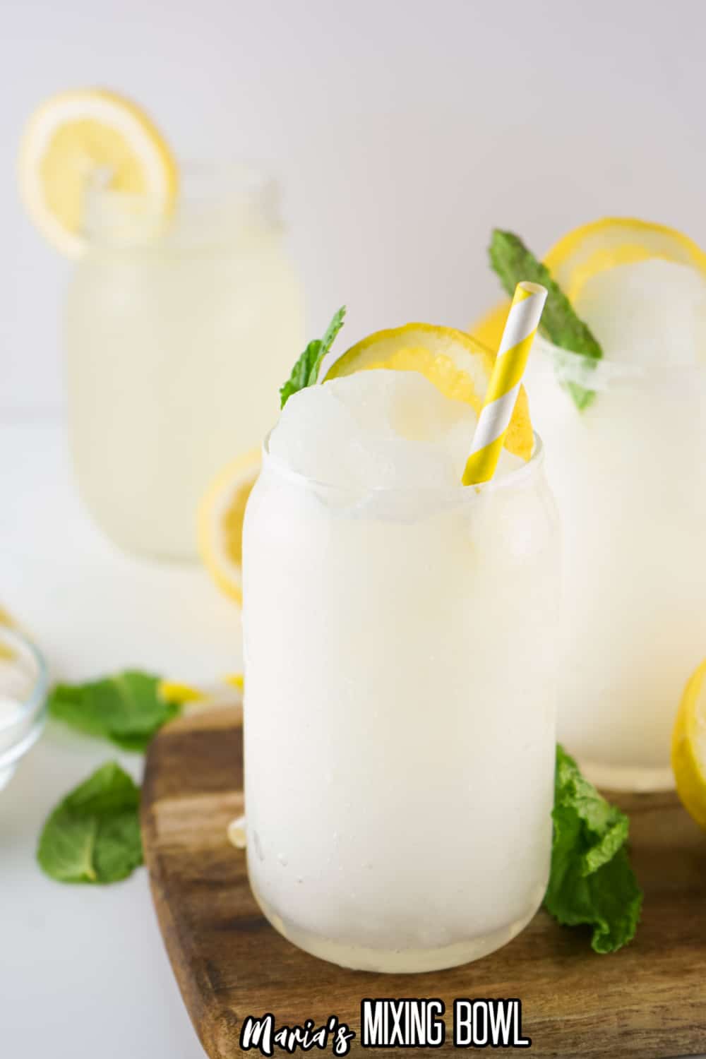 two lemonade slushies on a wooden cutting board