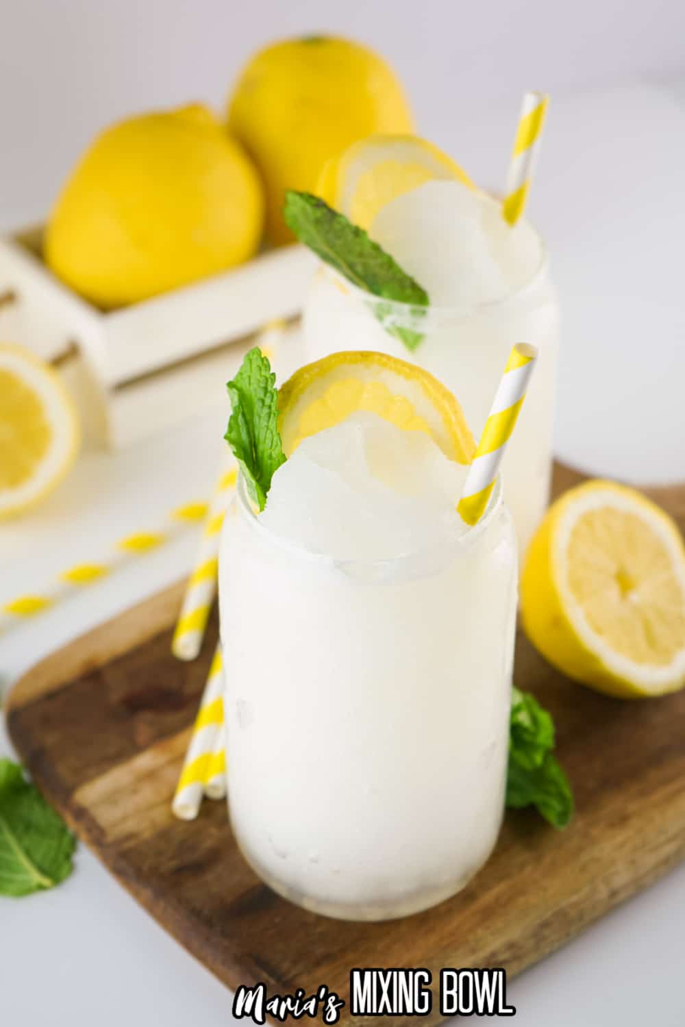 two lemonade slushies on a wooden cutting board