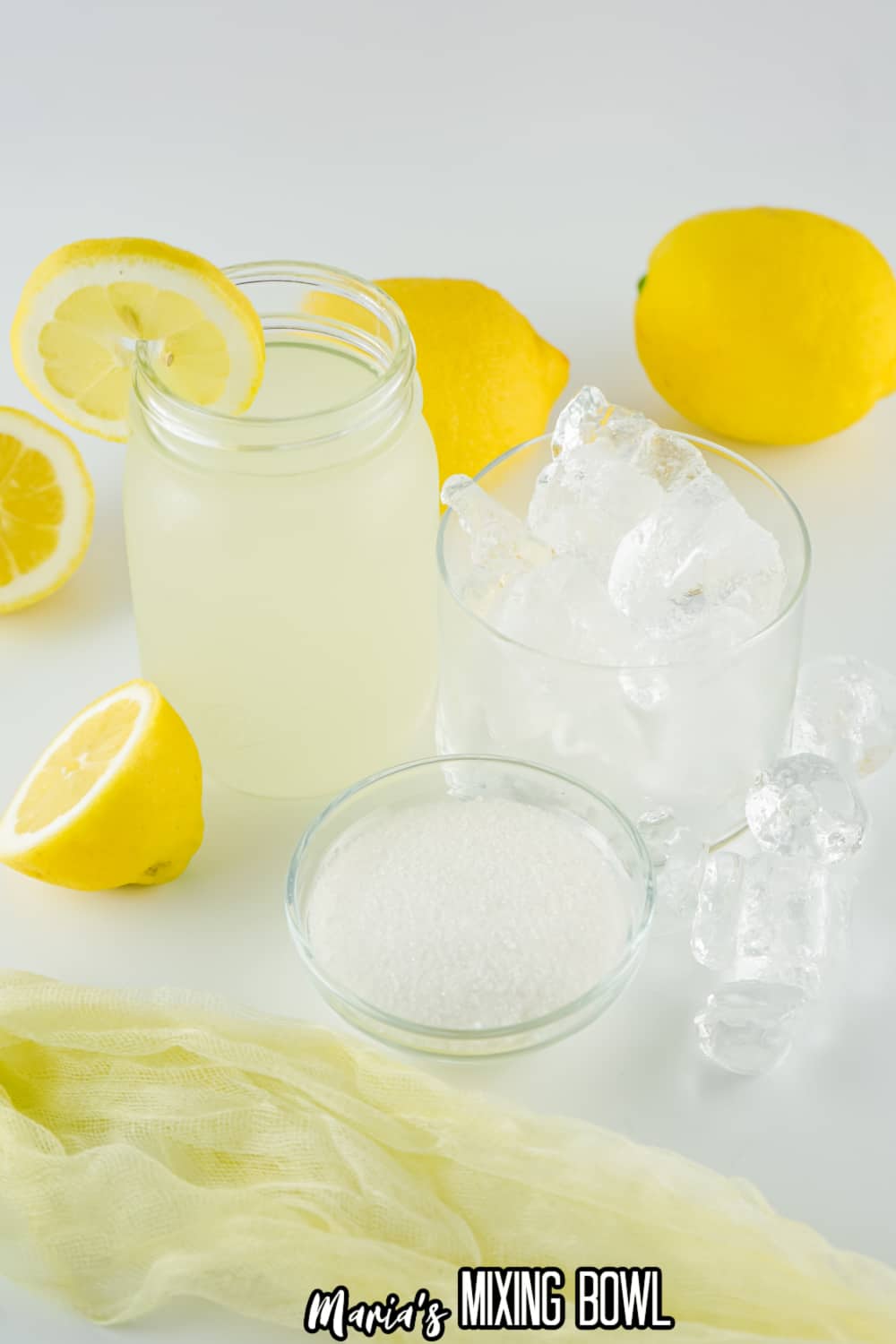 glasses of lemonade, ice and sugar on a white background