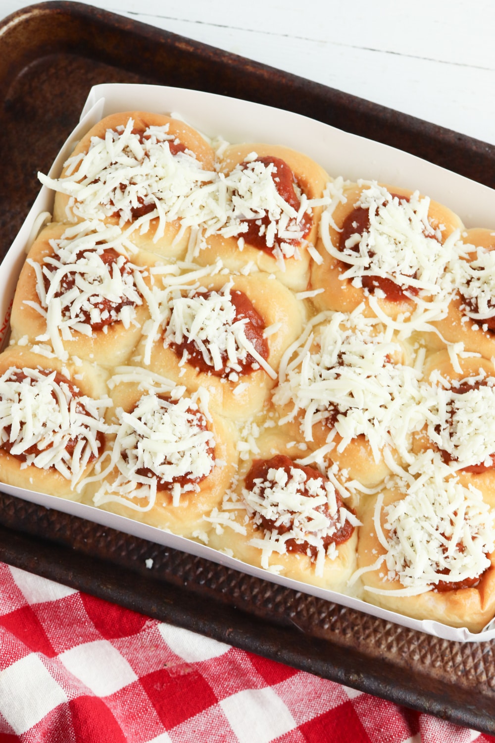 mozzarella cheese sprinkled on top of meatballs in the package