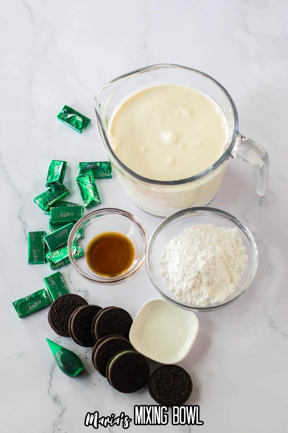 andes mints, heavy whipping cream, powdered sugar, vanilla extract, and oreo cookies on a white marble background