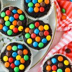 birds eye image of m&m brownies on a white plate with gold around the rim