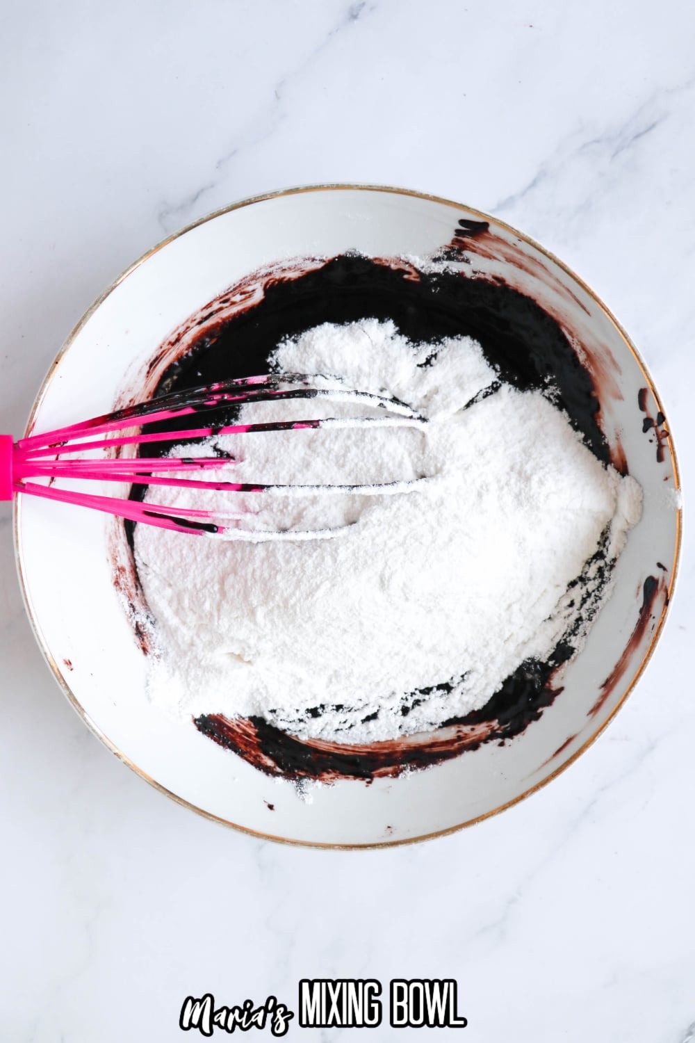 powdered sugar being added to the chocolate frosting