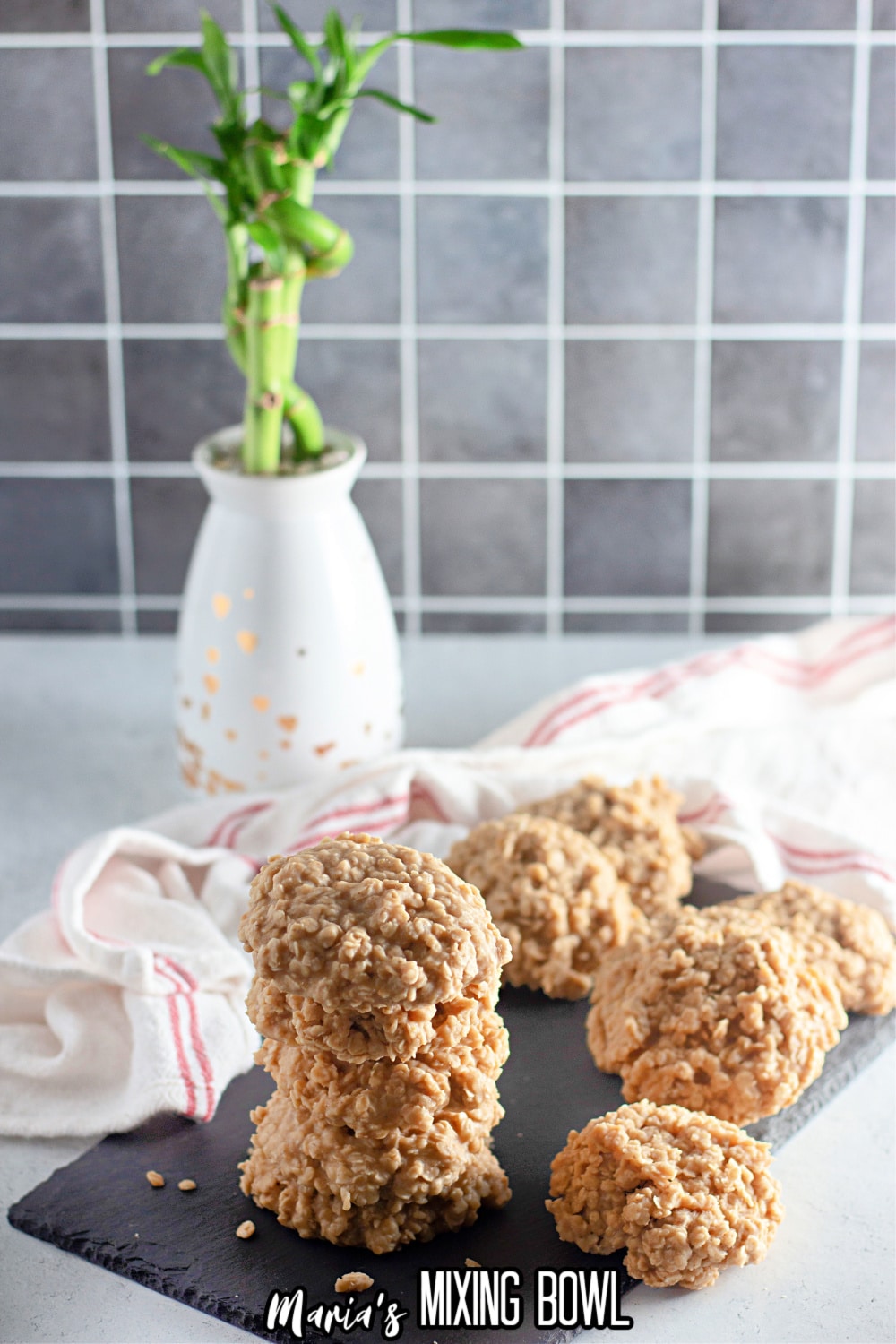 twelve no bake peanut butter cookies stacked up on a slate gray platter