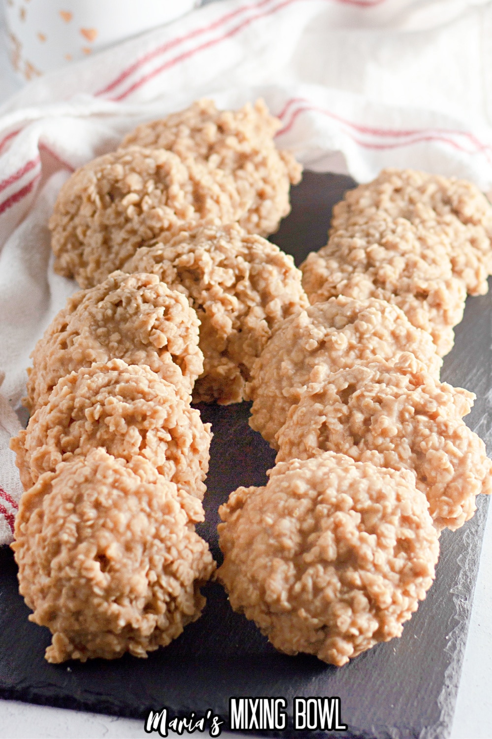 twelve no bake peanut butter cookies lined up on a slate gray platter