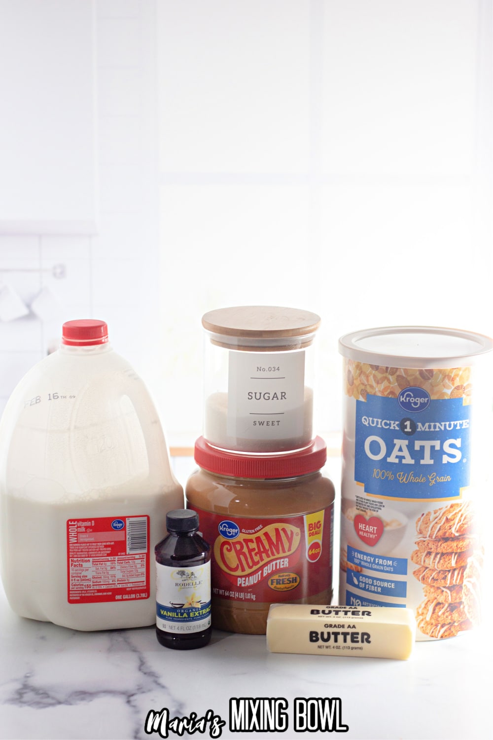 milk, sugar, vanilla, creamy peanut butter, butter, and oats on a white marble backdrop