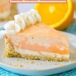slice of orange cheesecake on a white plate on top of a bright blue kitchen towel