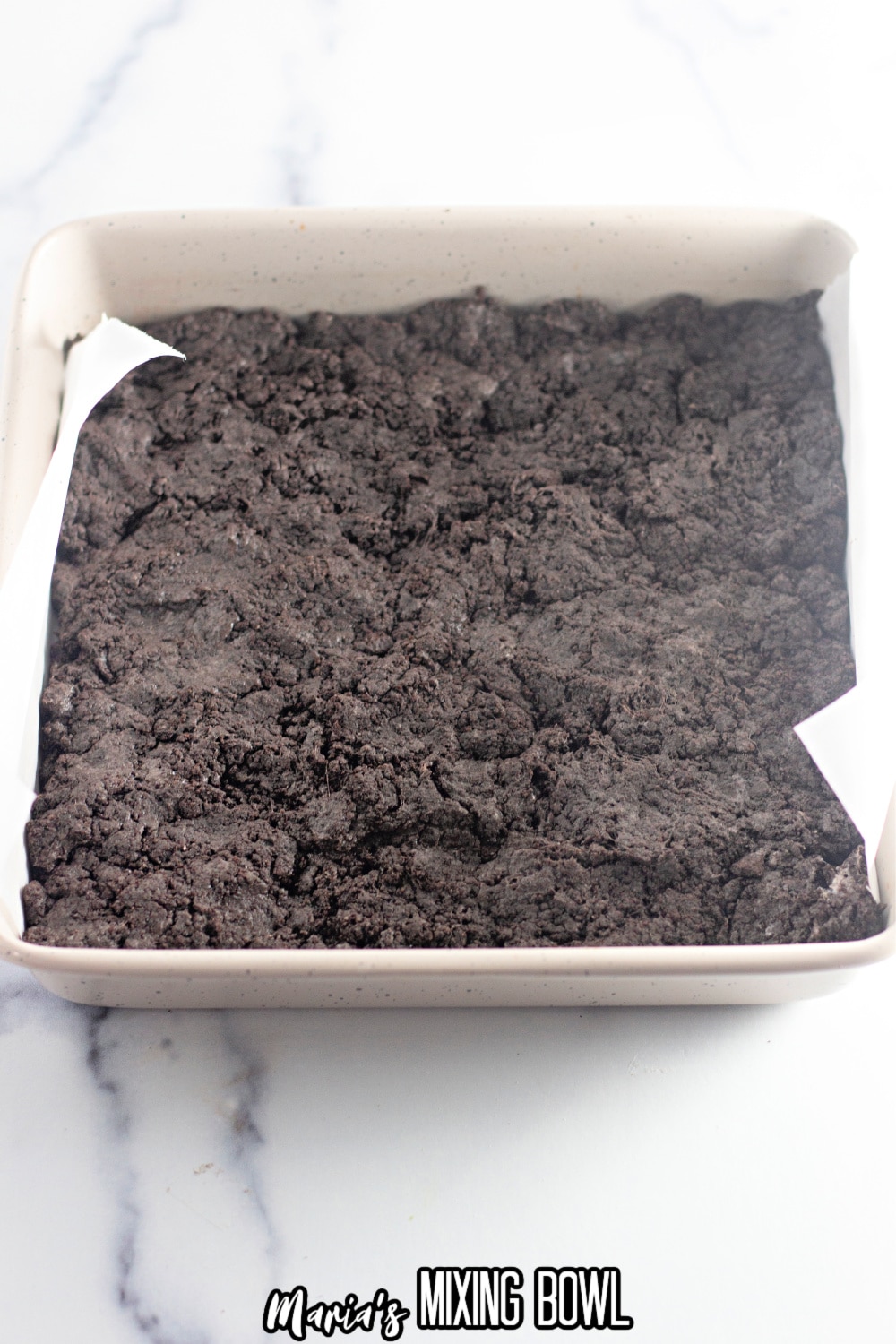 oreo marshmallow bars pressed into a parchment lined baking sheet