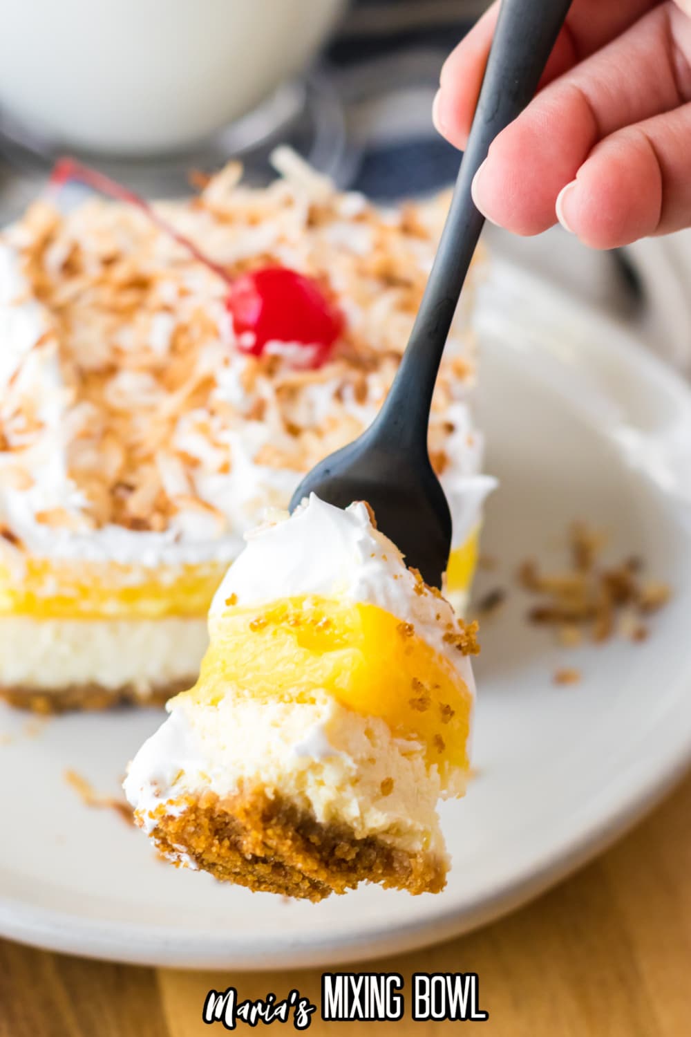 bite of pina colada cheesecake bar held in the air on a fork