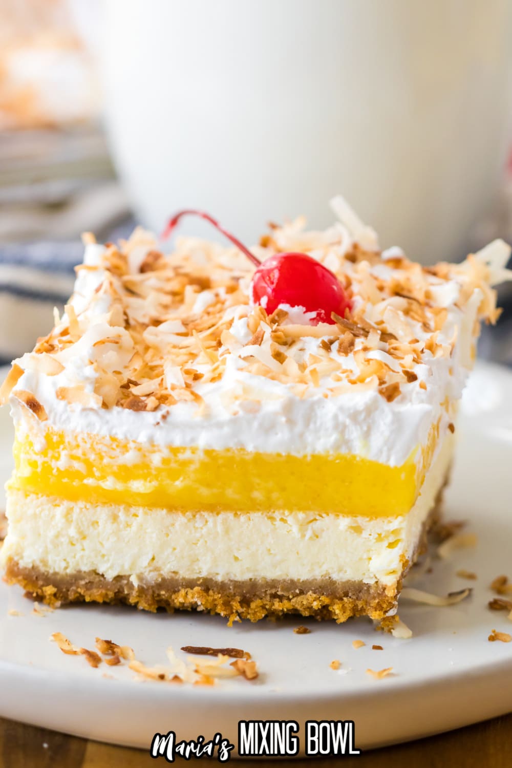 slice of pina colada cheesecake bars on a white plate with rimmed edges