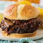 close up of sliced beef brisket sandwich on an off white plate