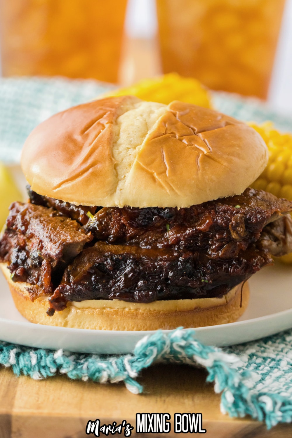 close up of sliced beef brisket sandwich on an off white plate