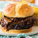 close up of sliced beef brisket sandwich on an off white plate