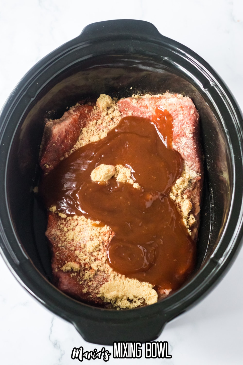 raw beef brisket, brown sugar, and bbq sauce in a slow cooker