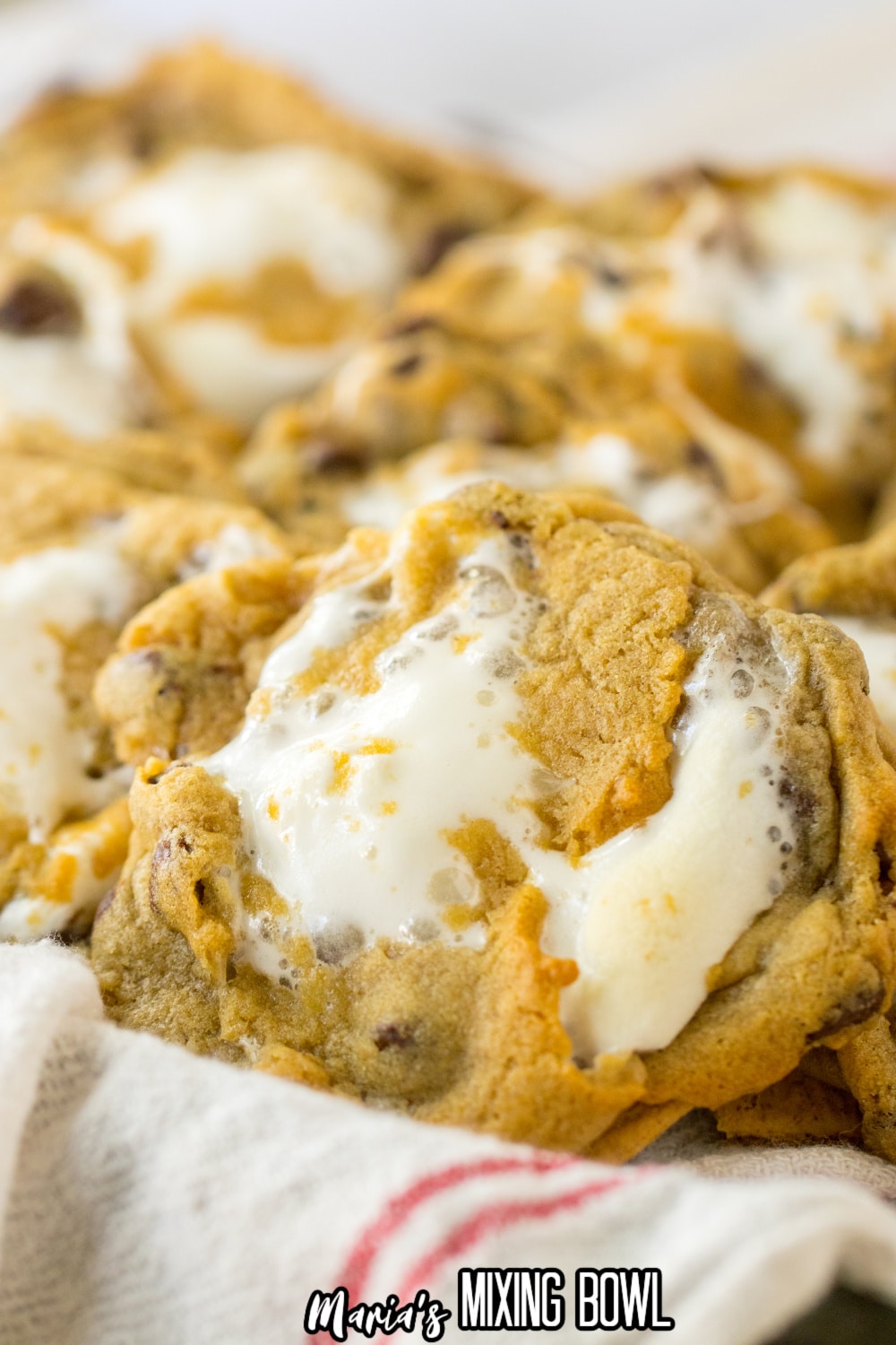 close up of smores cookies in a kitchen towel lined basket